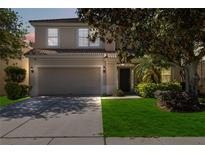 Charming two-story home features a well-maintained lawn and an attached two-car garage at 2509 Archfeld Blvd, Kissimmee, FL 34746