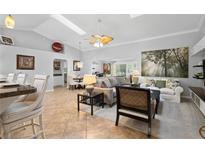 Bright living room featuring an open floor plan, skylights, ceiling fan, and comfortable seating at 26901 Racquet Cir, Leesburg, FL 34748