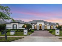 Stunning white home with a paver driveway, elegant landscaping, and a beautiful twilight sky at 3382 Fernlake Pl, Longwood, FL 32779