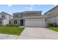 Charming two-story home features a well-manicured lawn and an attached two-car garage at 5660 Oak Knoll Dr, St Cloud, FL 34771