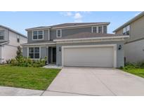 Charming two-story home boasts a manicured lawn and a convenient two-car garage at 5660 Oak Knoll Dr, St Cloud, FL 34771