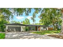 Charming single-story home featuring mature trees, a well-kept lawn, and an attached two-car garage at 605 Ensenada Dr, Orlando, FL 32825