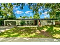 Charming single-story home featuring a well-maintained lawn and a two-car garage at 605 Ensenada Dr, Orlando, FL 32825