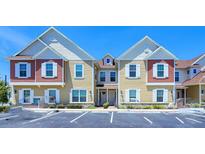 Charming townhouse with colorful siding, white trim, and parking spaces at 7595 Sunny Dreams Ln, Kissimmee, FL 34747