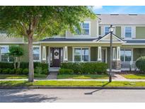 Inviting two-story townhome boasts lush landscaping, a charming front porch, and welcoming curb appeal at 8643 Coventry Park Way, Windermere, FL 34786
