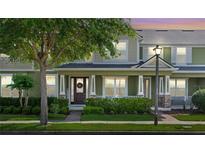Charming two-story home with a covered front porch, manicured lawn, and a welcoming entrance featuring a decorative wreath at 8643 Coventry Park Way, Windermere, FL 34786