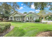Charming one-story home featuring a well-manicured lawn and inviting front porch with rocking chairs at 89 Pine Forest Ln, Haines City, FL 33844