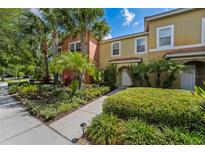 Charming townhome exterior featuring vibrant landscaping and a well-maintained walkway to the entrance at 3045 Yellow Lantana Ln, Kissimmee, FL 34747