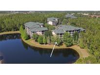 Beautiful aerial view of lakeside condos with lush landscaping and tranquil surroundings at 9061 Treasure Trove Ln # 104, Kissimmee, FL 34747