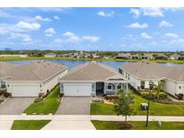 Charming single-story home with a water view, lush landscaping, and a brick-paved driveway at 6137 Blue Pond Way, St Cloud, FL 34771