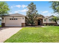 Charming single-story home boasts a lush lawn, brick driveway, and stone accents for added curb appeal at 972 Bighorn St, Oviedo, FL 32765