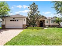 Charming home with stone accents, two car garage, brick driveway, and beautifully maintained lawn at 972 Bighorn St, Oviedo, FL 32765