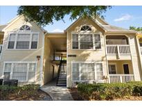 Charming yellow two-story condo building with well-maintained landscaping and inviting entryway at 1063 S Hiawassee Rd # 1615, Orlando, FL 32835