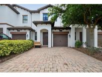 Inviting two-story townhome featuring a paver driveway and attached one-car garage at 1350 Royal St George Blvd, Davenport, FL 33896