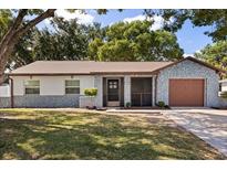 Charming single-story home with a well-maintained lawn, attached garage, and a unique stone facade on the exterior at 1360 Springfield St, Kissimmee, FL 34744