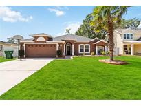 Beautiful one-story home with a lush green lawn, mature palm tree, and a two-car garage at 18 Cooledge St, Winter Garden, FL 34787