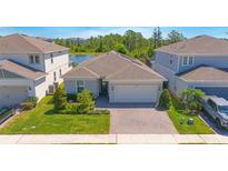 Charming single-Gathering home with brick driveway, well-manicured lawn, and two-car garage at 2490 Southlawn Ln, Clermont, FL 34714