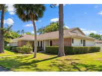 Charming single-story home with brick accents, a well-manicured lawn and mature trees adding to its curb appeal at 400 Woodview Dr, Longwood, FL 32779