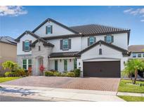 Beautiful two-story home featuring a brick driveway and stone accents, along with a two car garage at 8109 Ludington Cir, Orlando, FL 32836