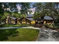 Stunning exterior of log cabin style home with stone details, mature trees, and a welcoming front yard at 840 Dyson Dr, Winter Springs, FL 32708