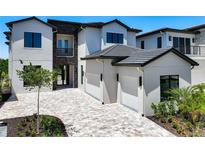 Beautiful two-story home with a brick driveway, three car garage, and landscaped yard at 1080 E Jack Nicklaus Ct, Kissimmee, FL 34747