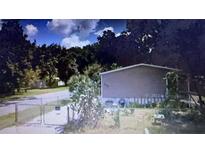 Modest home with neutral siding, surrounded by trees, and a chain-link fence in the front yard at 126 2Nd St, Orlando, FL 32824