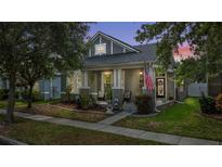 Charming single-Gathering home with a well-maintained front yard and cozy front porch with patriotic decor at 14131 Paradise Tree Dr, Orlando, FL 32828