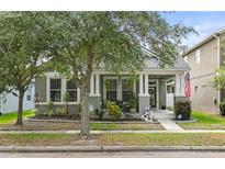 Charming single-Gathering home with a well-maintained front yard and cozy front porch with patriotic decor at 14131 Paradise Tree Dr, Orlando, FL 32828