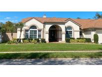 Charming home featuring a well-manicured lawn and decorative shrubbery at 1474 Thornhill Cir, Oviedo, FL 32765