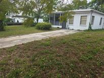 A single-story home with a front yard and a concrete driveway leading up to the screened-in porch at 2507 Lafayette Ave, Winter Park, FL 32789