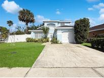 Charming two-story home with a well-manicured lawn, tropical landscaping, and a two-car garage at 2601 Spring Hill Dr, Kissimmee, FL 34743