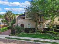 Stunning two-story home with lush landscaping, brick driveway, and charming architectural details at 511 Woodlawn Blvd, Orlando, FL 32801