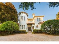 Elegant two-story home with a turret and a brick driveway provides a charming, stately appeal at 6143 Cartmel Ln, Windermere, FL 34786