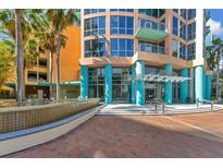 Inviting condo exterior featuring colorful architecture, lush palm trees, and a serene water fountain at 322 E Central Blvd # 1008, Orlando, FL 32801