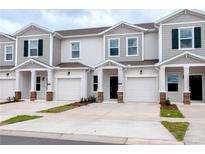 Charming townhomes featuring individual garages and lovely architectural details, offering modern comfort and curb appeal at 3239 Laurent Loop, Davenport, FL 33837