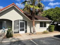 Charming home exterior featuring a red tile roof, stucco walls, and a mature palm tree in the front yard at 3530 Forest Branch Dr # F, Port Orange, FL 32129