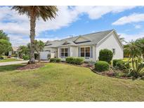 Well-maintained home with lush landscaping, featuring a manicured lawn and attractive plantings at 433 Arcadia Lakes Dr, The Villages, FL 32162