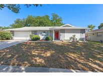 Charming single-story home with a red front door, manicured landscaping, and attached garage at 611 Green Briar Blvd, Altamonte Springs, FL 32714