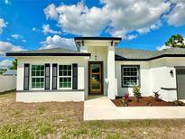 Charming single-story home featuring a modern design, decorative shutters, and a beautifully landscaped front yard at 701 Marion Oaks Trl, Ocala, FL 34473