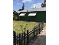 Charming home featuring a dark green exterior, metal roof, fenced yard and white window awnings at 710 W Swoope W Ave, Winter Park, FL 32789