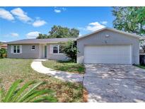 Charming single-story home with a well-maintained lawn, paved walkway, and attached two-car garage at 7709 Pine Hollow Ct, Orlando, FL 32822