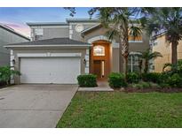 Charming two-story home features a well-maintained lawn, attached two-car garage and manicured landscaping at 8404 Secret Key Cv, Kissimmee, FL 34747