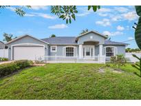 Charming single-story home with a well-manicured lawn and a white picket fence at 1819 E Chapel Dr, Deltona, FL 32738