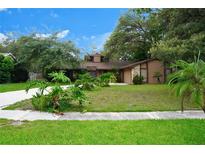 Charming single-story home with lush landscaping and a well-manicured lawn at 490 Burnt Tree Ln, Apopka, FL 32712