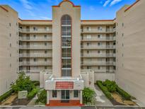 Multi-story condo building featuring balconies, red roof accents, landscaping, and street-facing entry with the address 1150 at 1150 Carmel Cir # 301, Casselberry, FL 32707