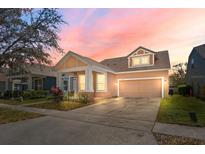 Charming single-Gathering home featuring a well-manicured lawn and a convenient two-car garage at sunset at 14720 Sweet Acacia Dr, Orlando, FL 32828