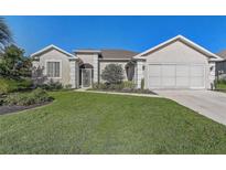Charming single-story home with well-manicured lawn and stucco facade at 1900 Nw 57Th Ct, Ocala, FL 34482