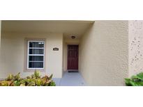 Inviting townhome entrance with a red front door and well-maintained landscaping at 2812 Club Cortile Cir # A, Kissimmee, FL 34746