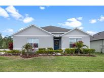 Charming single-story home with well-manicured lawn, landscaping, and blue front door with decorative wreath at 2900 Sunridge Loop, St Cloud, FL 34771