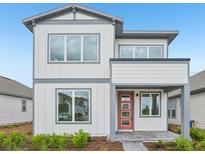 Modern two-story home featuring white siding, gray trim, a red front door, and neatly landscaped yard at 2980 Embark Trail, St Cloud, FL 34771